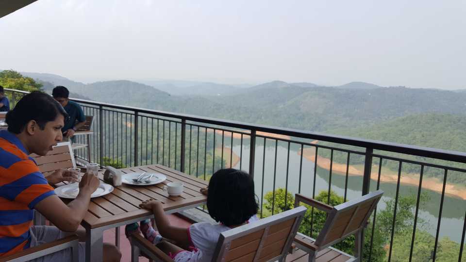 Aravind and Laasya having breakfast at Munnar overlooking the Ponmudi Reservoir