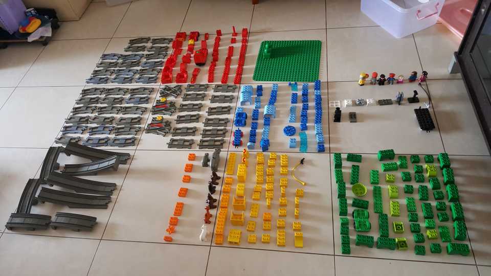 Lots of Lego Duplo pieces laid out on the floor